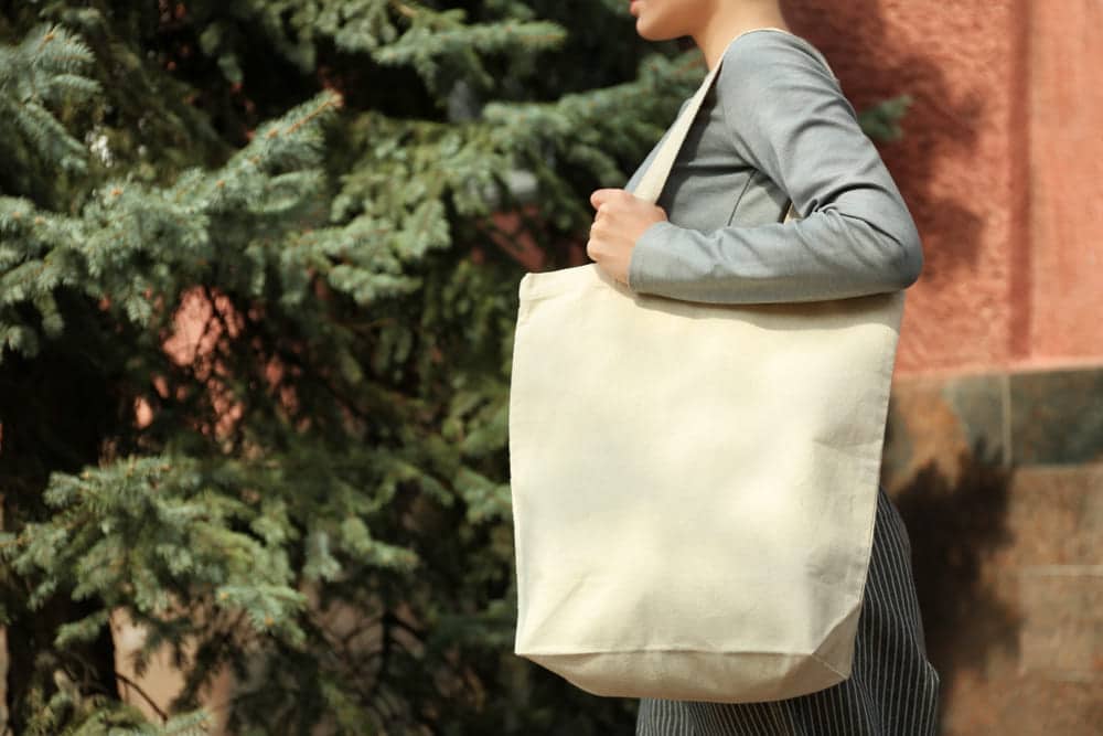Mulher carregando suas compras em uma sacola ecológica de pano.